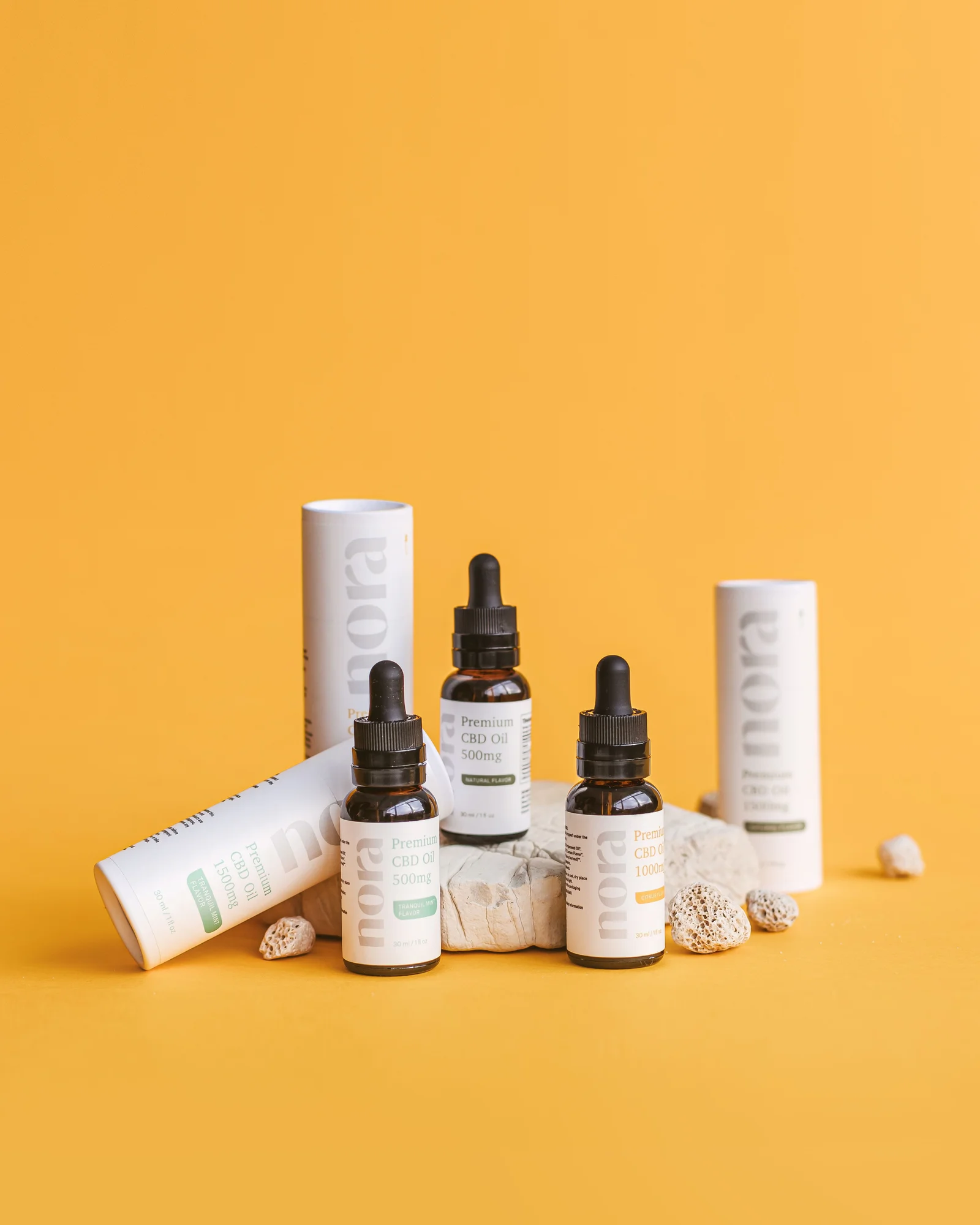 Serum and spray skincare products arranged against a yellow background