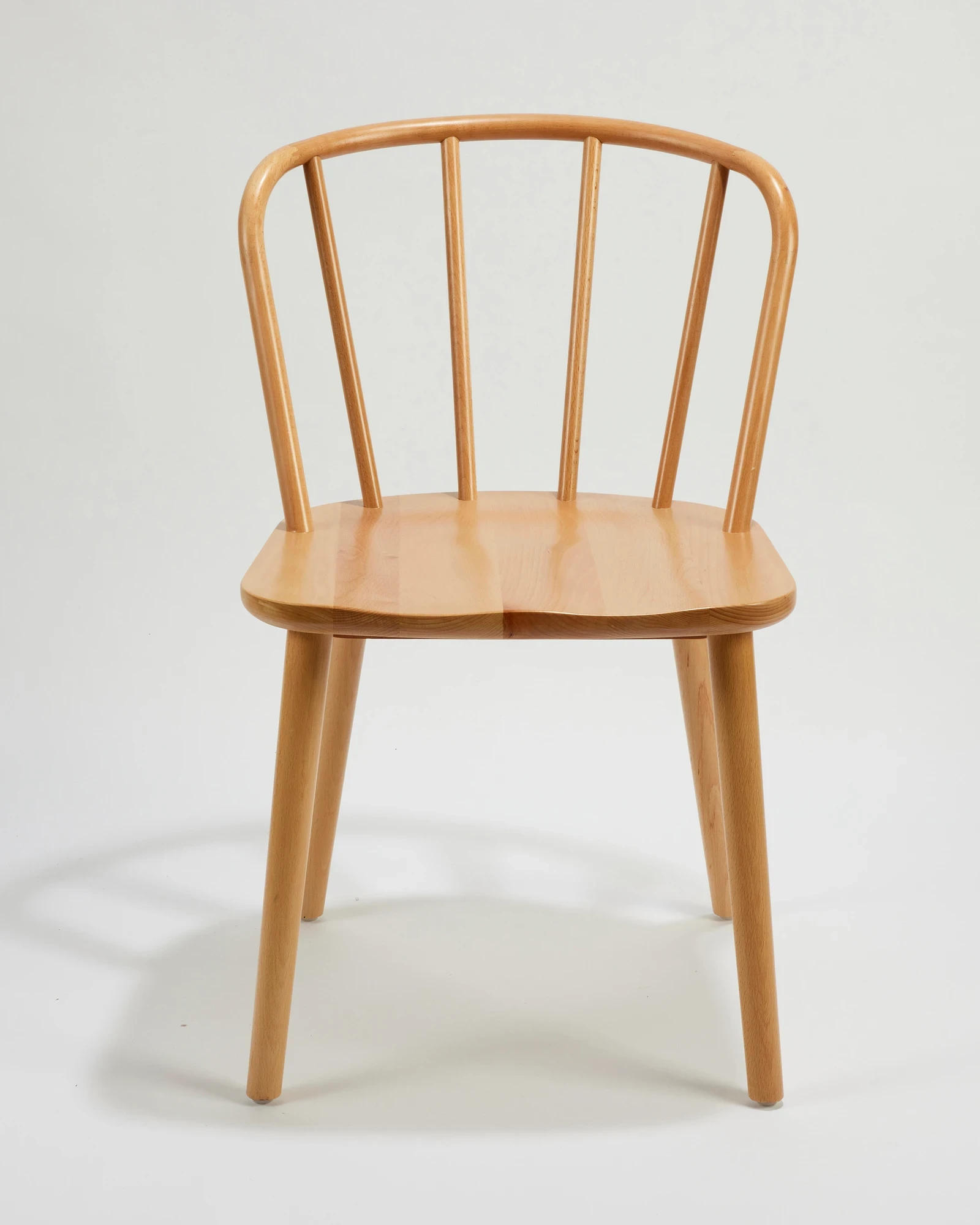 Wooden spindle chair photographed against its original studio background