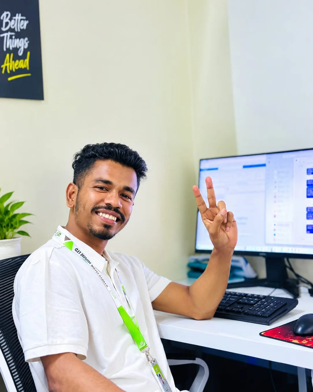 Studio Click House team member smiling at his workstation