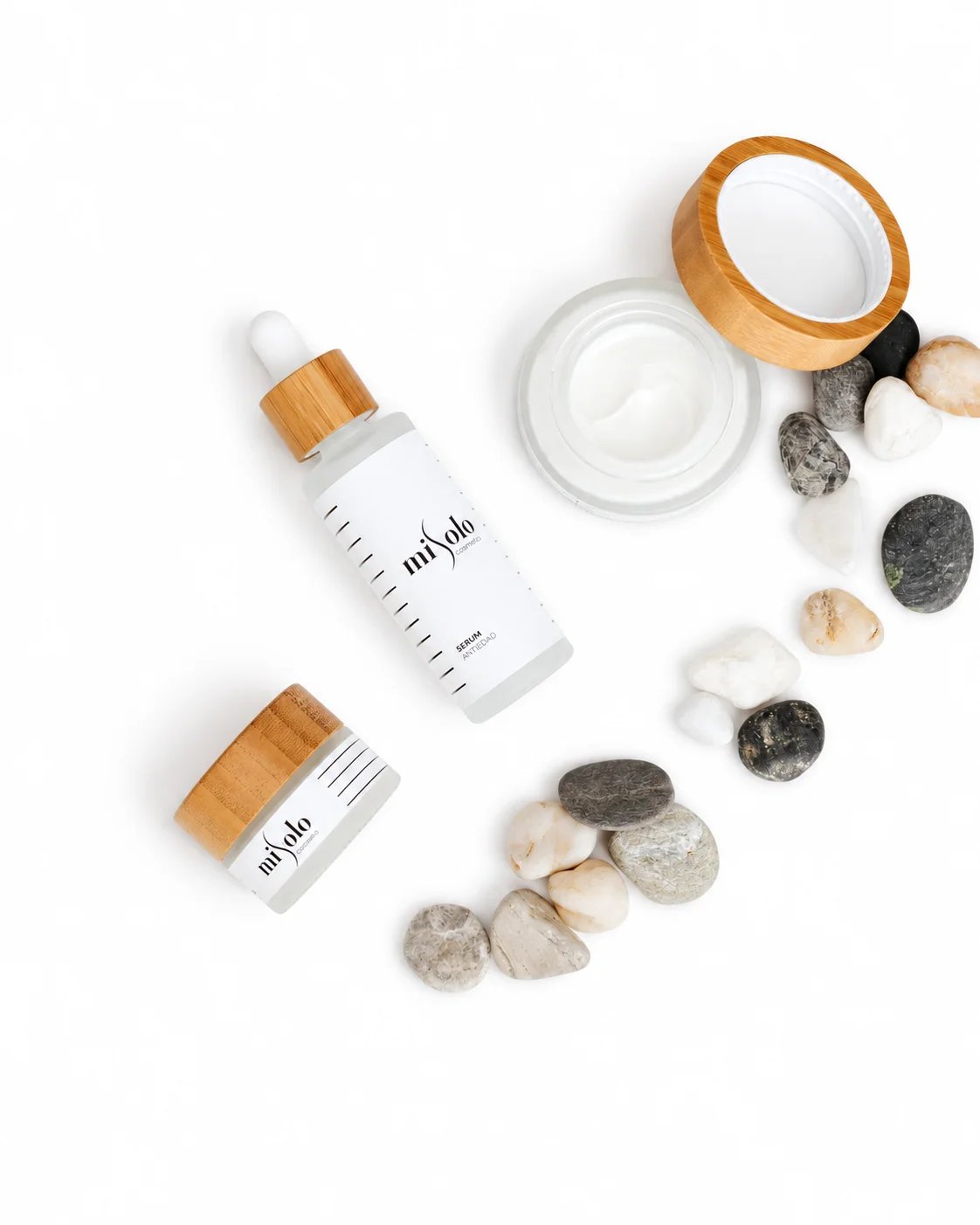 Misolo skincare serum, cream, and dropper bottles styled with zen stones