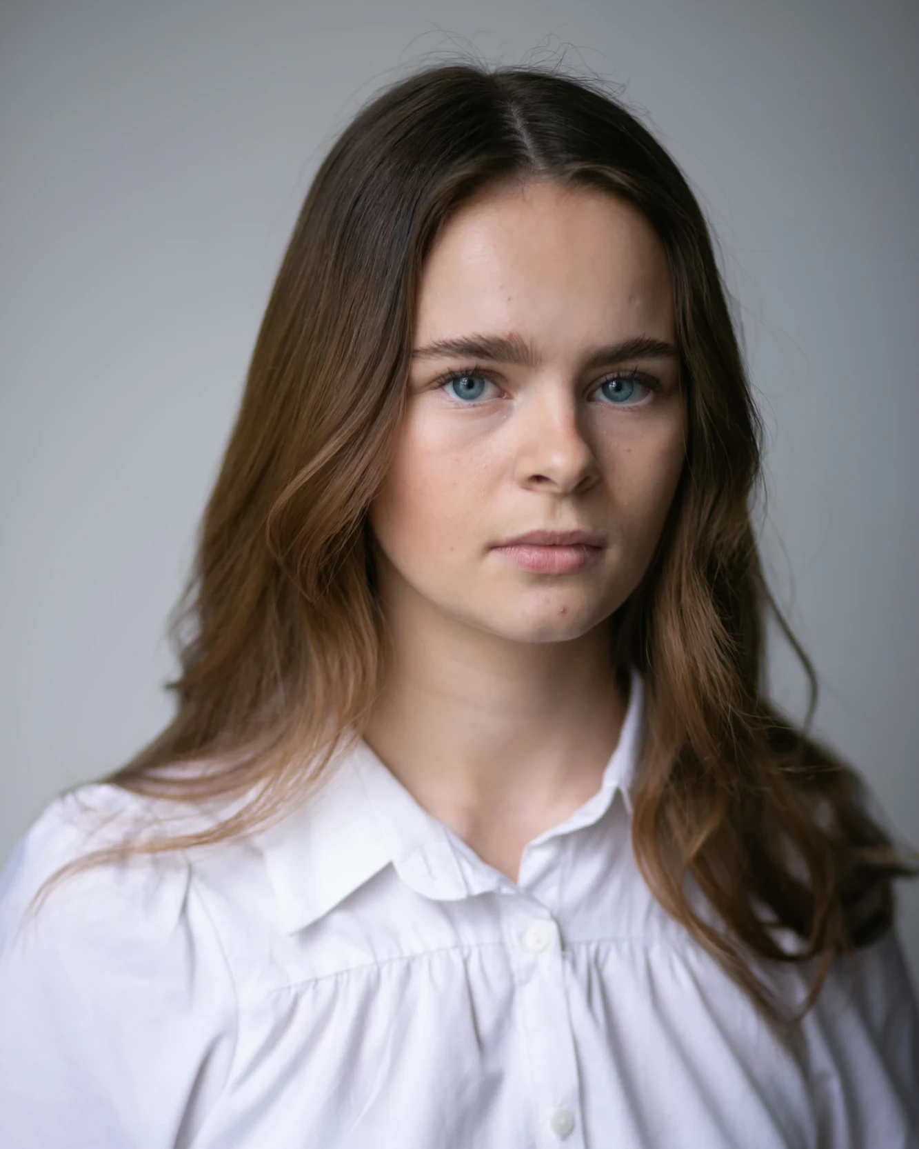 Female headshot before retouching, with visible skin texture and small blemishes