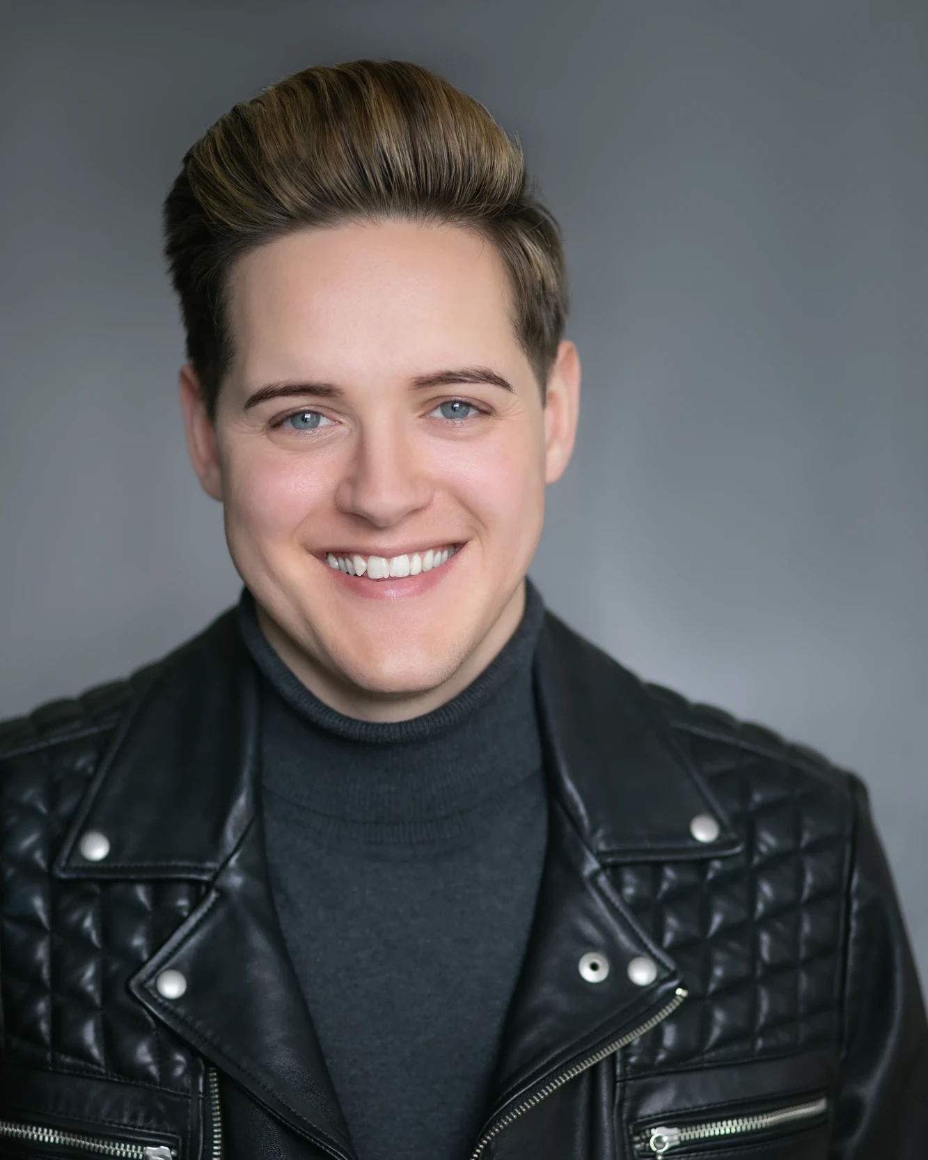 Male editorial headshot in a black leather jacket with refined skin detail