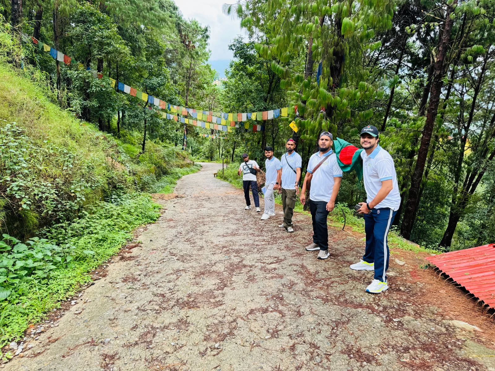 Studio Click House colleagues walking along mountain pine trail with Bangladesh flag