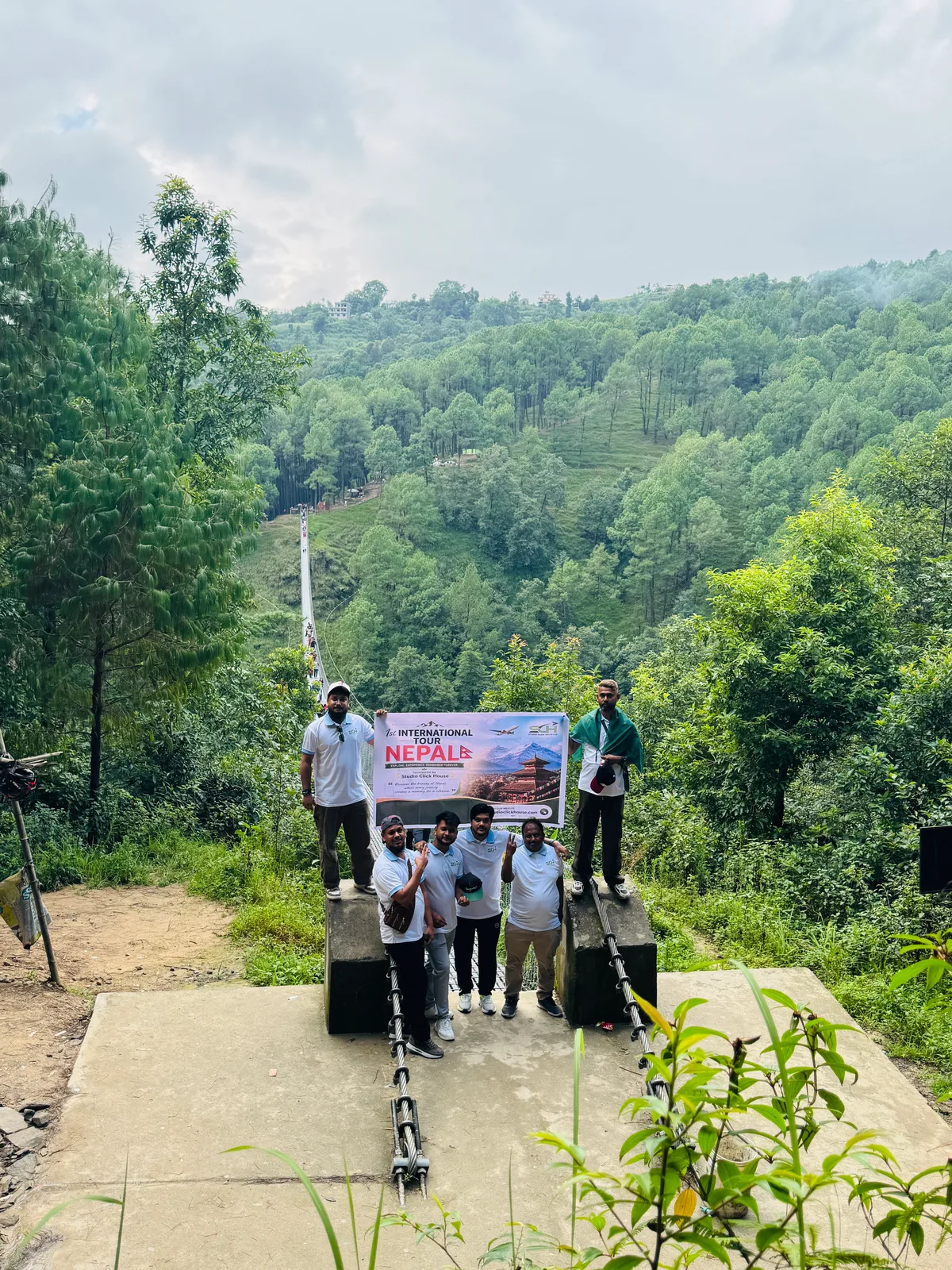 Studio Click House team proudly holding tour banner at bridge crossing