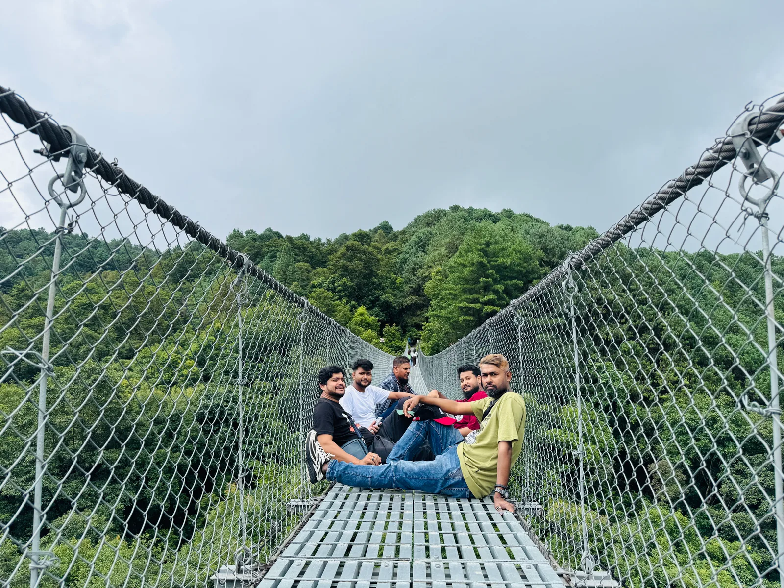 Studio Click House team sitting together along the high suspension bridge