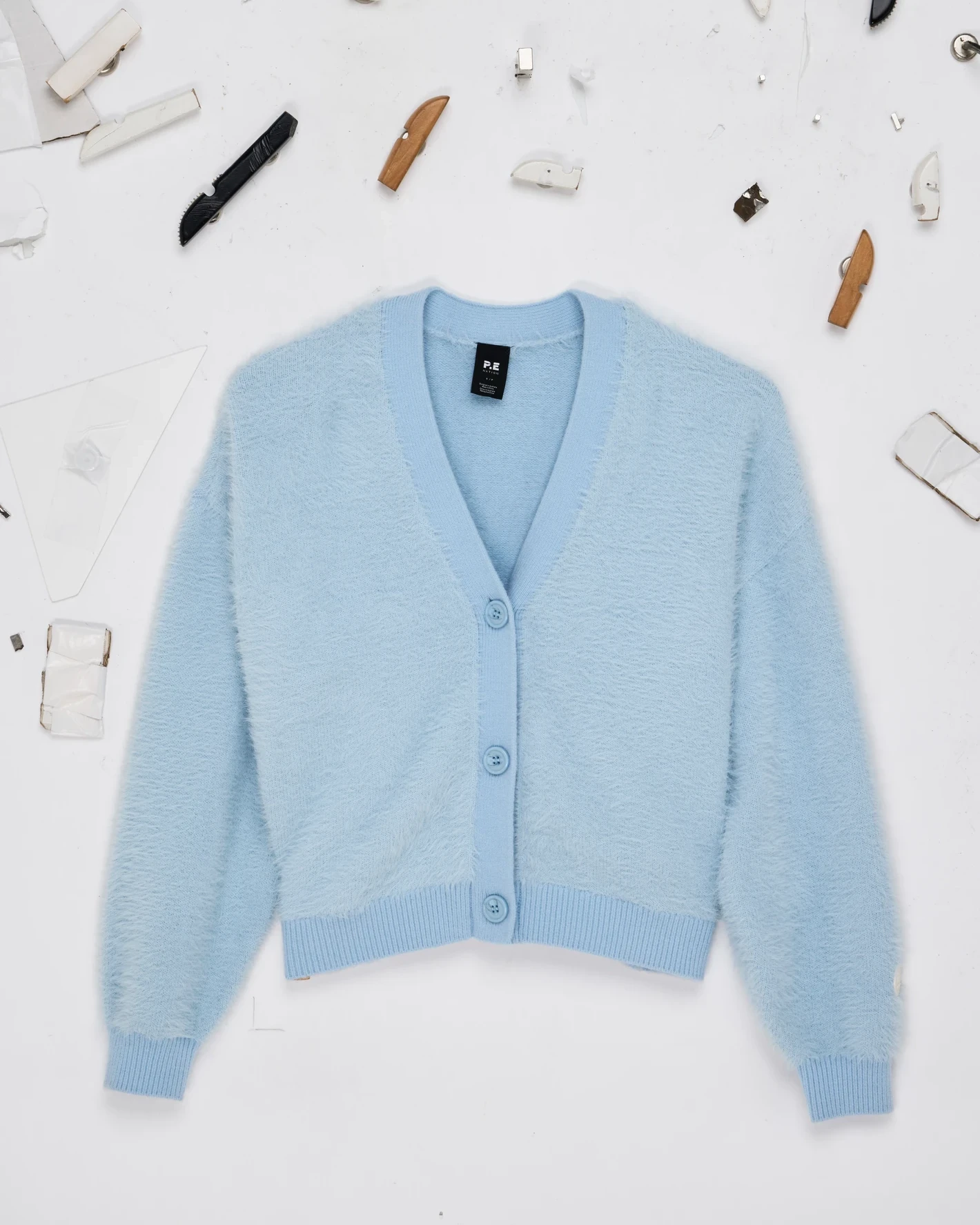 Ice-blue knit cardigan unedited overhead flat lay before styling and straightening